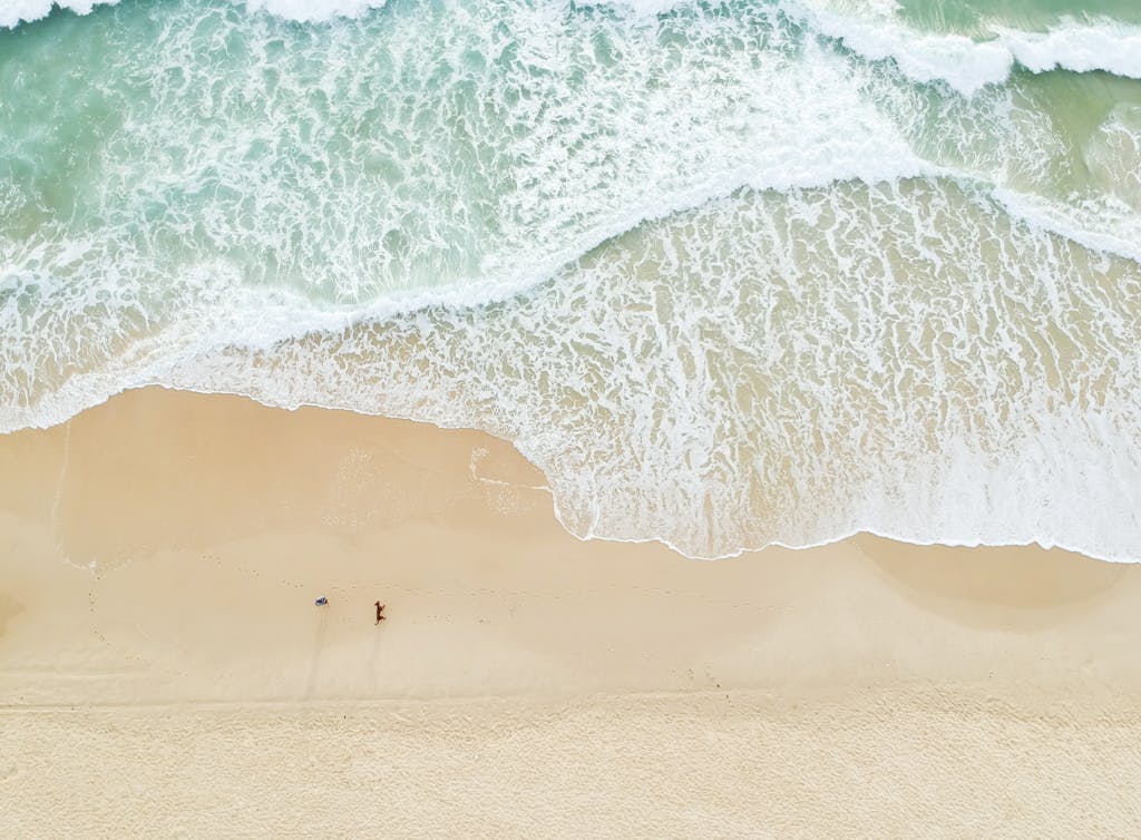 Serene aerial view of Castaways Beach in Queensland with gentle waves and sandy shores.