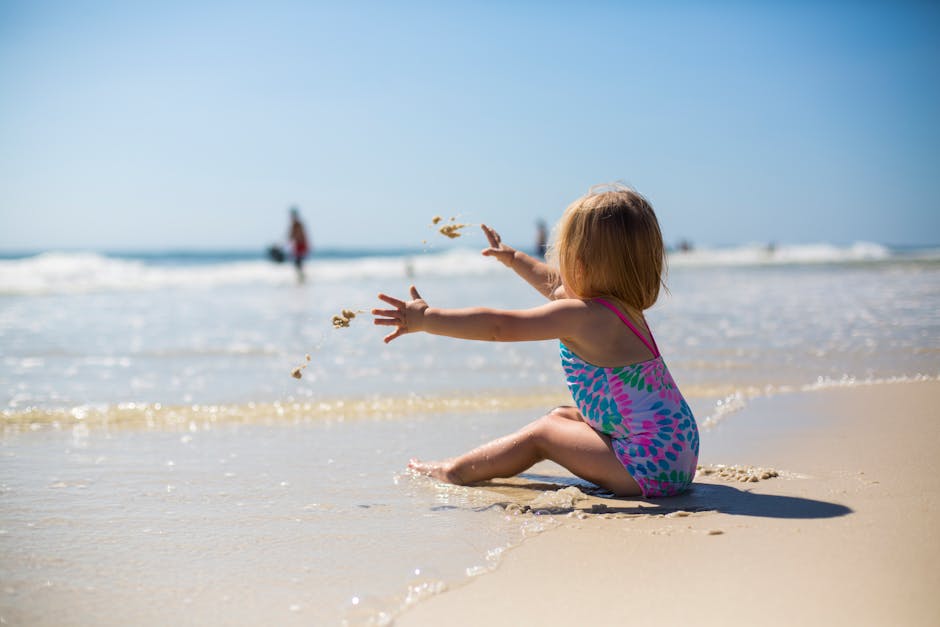 pexels-photo-1712855-1712855 A toddler enjoying the sunny beach while playing with sand, capturing a moment of pure joy and innocence.